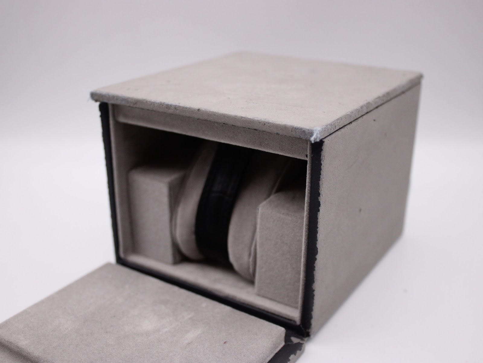 Side view of the grey Gc watch box with the watch removed, showing the internal cushion.