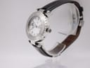 Side perspective view of the Gc watch on a stand, showing the crown and textured bezel.