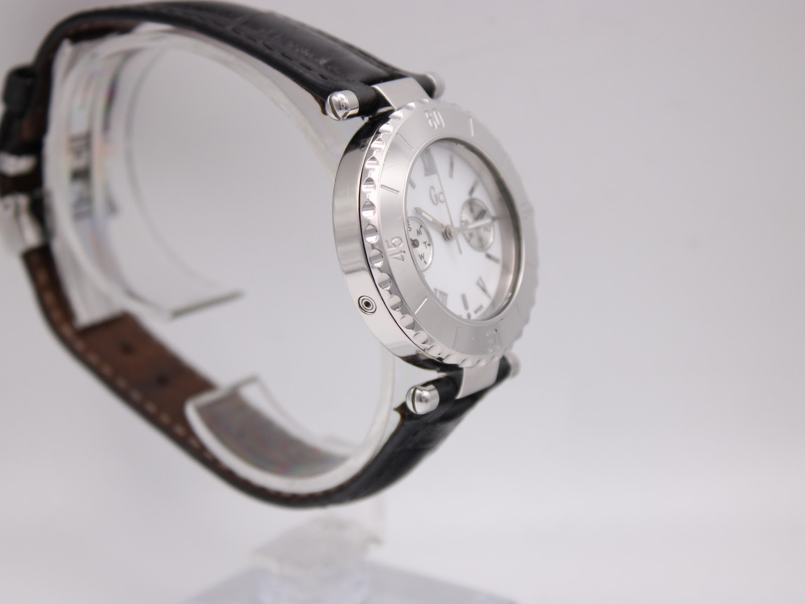 Opposite side perspective view of the Gc watch on a stand, highlighting the case profile and strap connection.