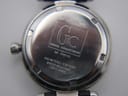 Close-up of the polished stainless steel case back with "Gc Guess Collection 14014L" and "100 metres / 330 feet Water Resistant Swiss Made" engravings.