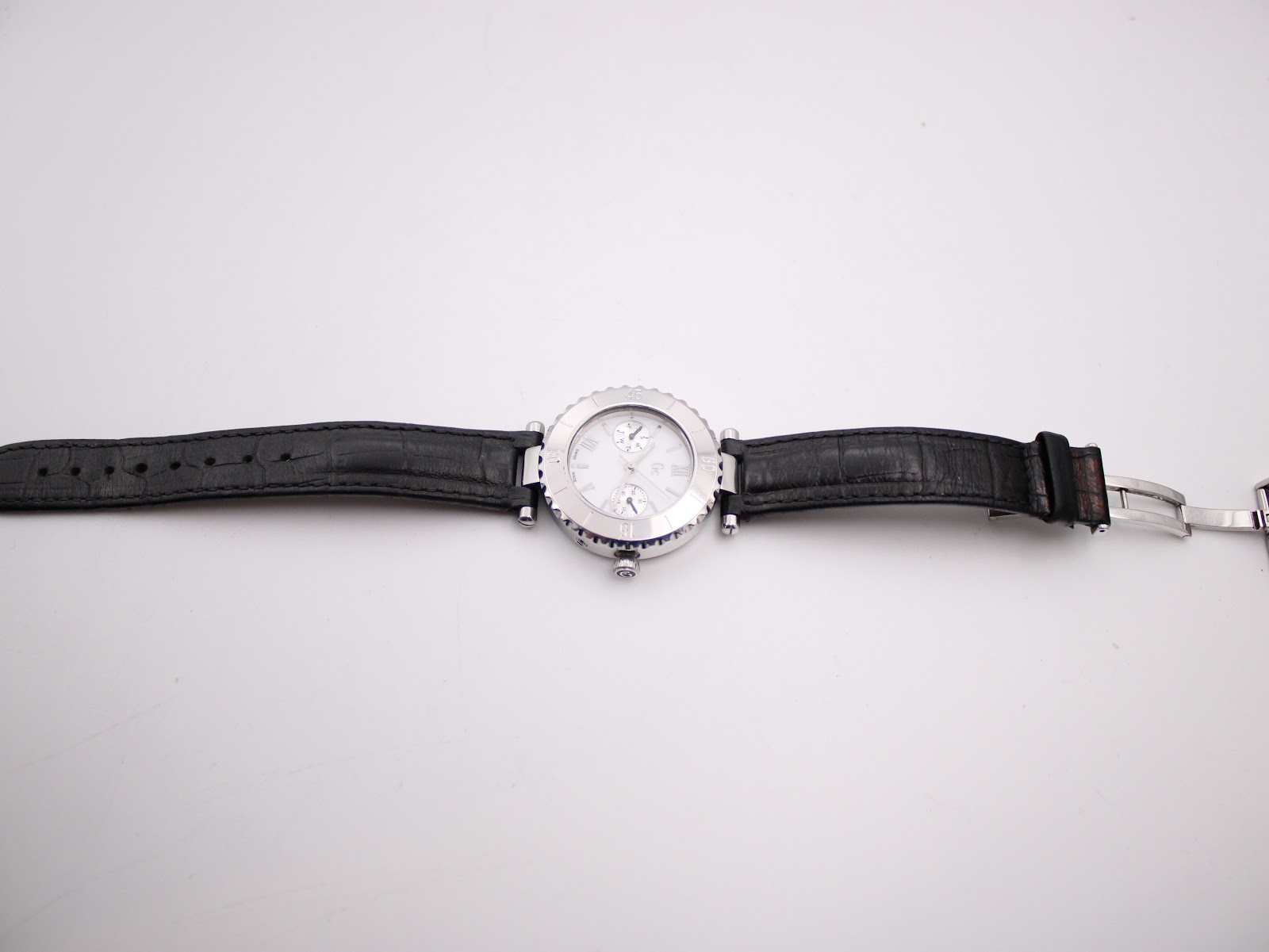 Full length view of the Gc watch with black leather strap and deployant clasp unfastened.