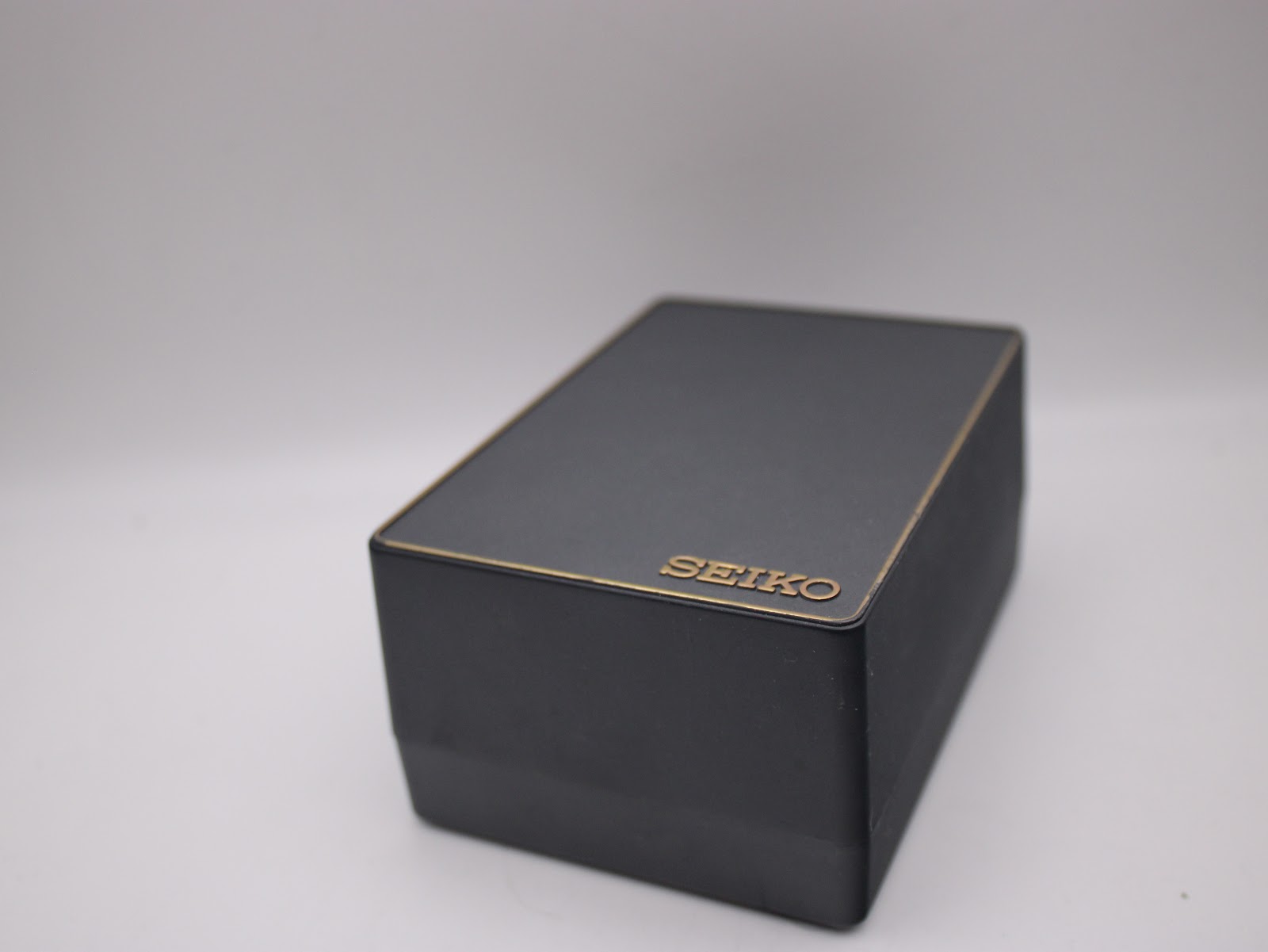 Top view of the original black Seiko watch box with gold 'SEIKO' lettering.