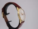Opposite side profile view of the gold plated Seiko watch on a display stand, showing the curved lugs.