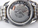 Close-up of the Seiko Kinetic 5M42A movement, revealing the oscillating weight, coil, and 'Japan 2 Jewels' engraving.