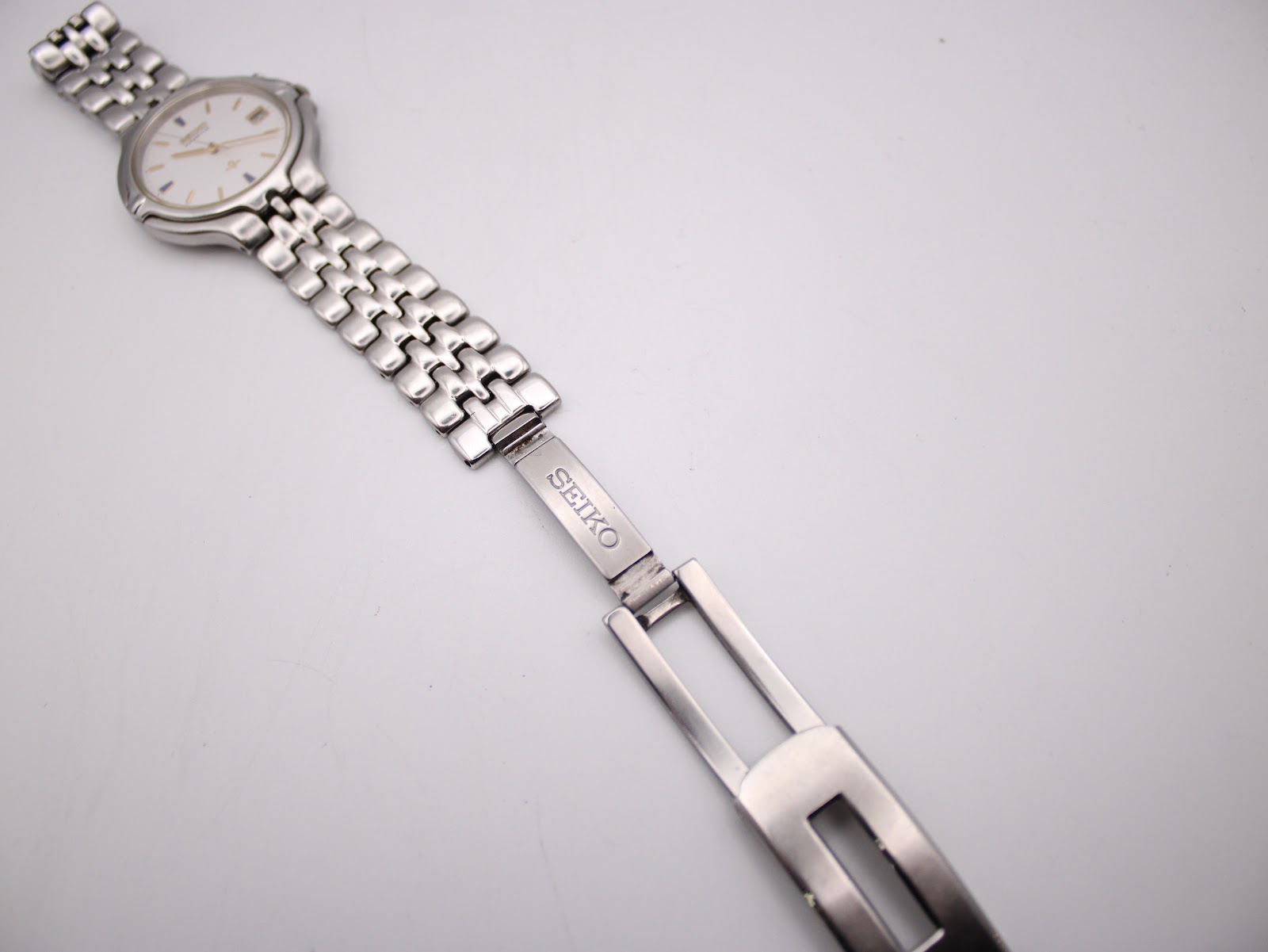 Top-down view of the integrated stainless steel bracelet and signed Seiko deployant clasp.