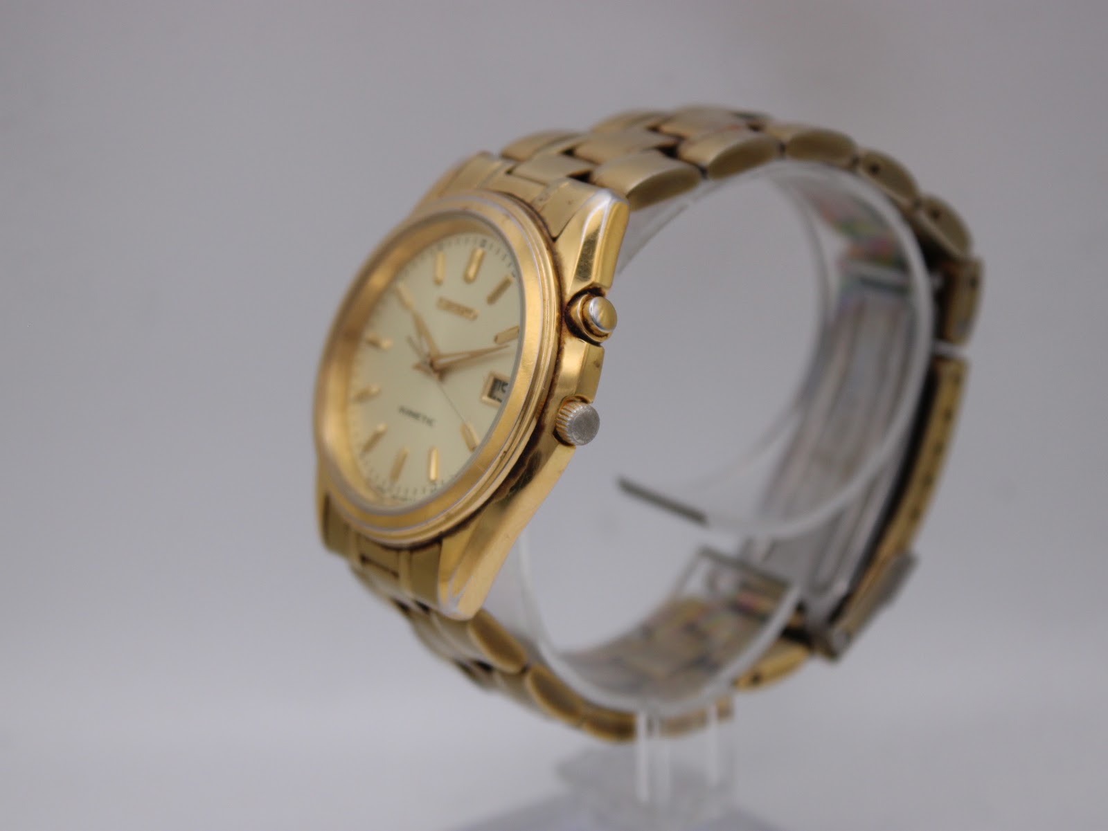 Angled side view of the gold Seiko Kinetic watch showing the crown and case profile.