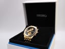 Angled view of the gold-tone Seiko 5T52-7A2A world timer watch in its original black and white Seiko box.