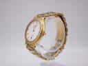 Angled view of the Seiko SQ100 watch, showcasing the gold-toned case and integrated bracelet on a clear stand.
