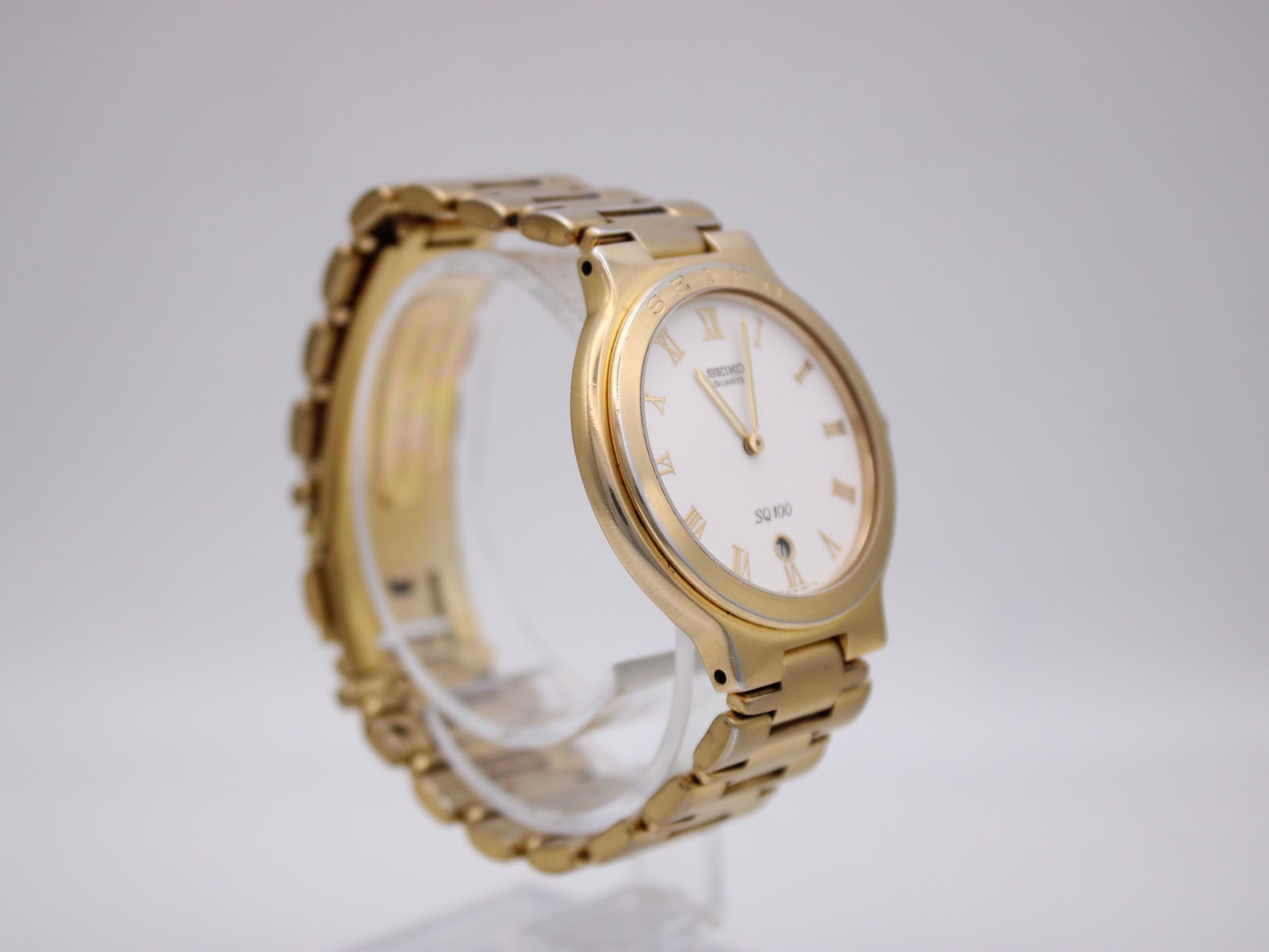 Reverse angled view of the gold-toned Seiko quartz watch, highlighting the case profile and bracelet links.