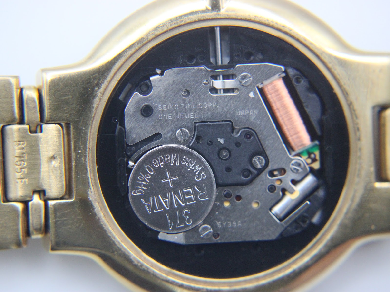 Macro shot of the Seiko quartz movement inside the watch, showing the Renata battery and "Seiko Time Corp." engraving.