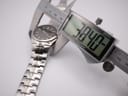 Digital caliper measuring the case diameter of the Seiko watch, showing 38.40mm on the display.