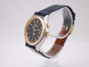 Angled view of the Seiko Kinetic watch showing the right side of the case, gold-tone crown, and push-button.