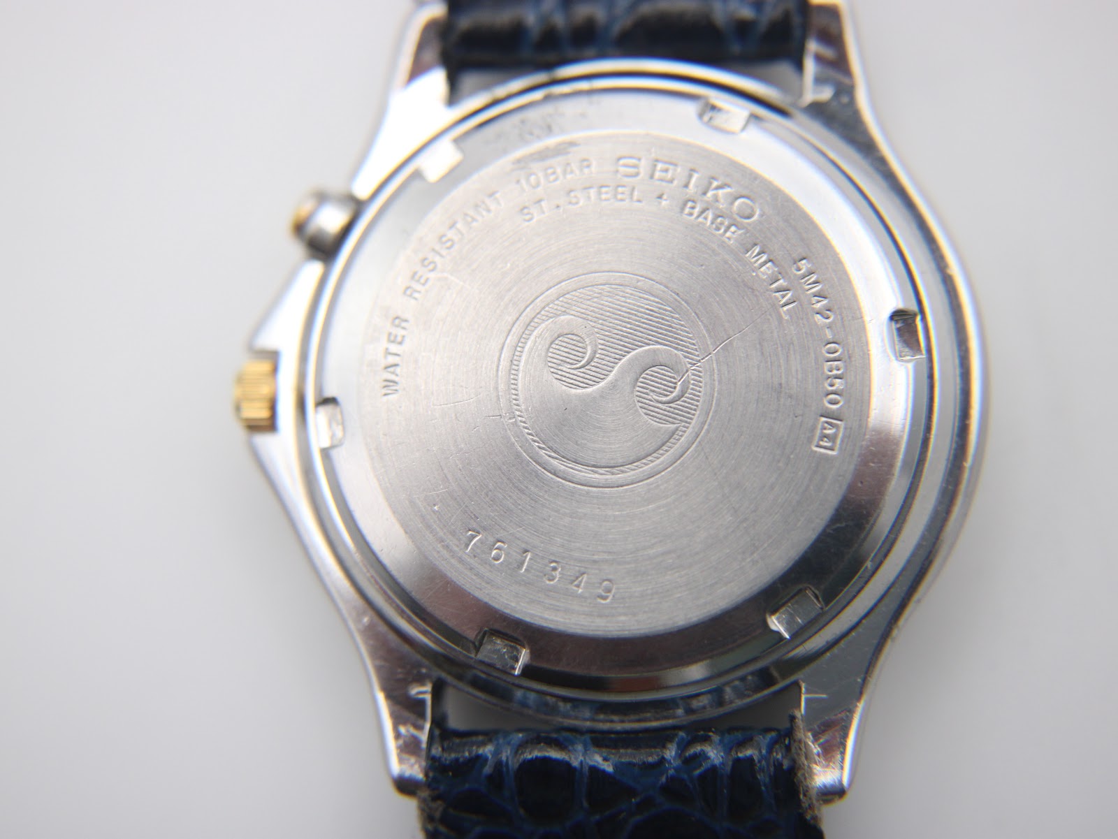 Close-up of the stainless steel case back with Seiko branding, model number 5M42-0B50, water resistance rating, and serial number 761349.