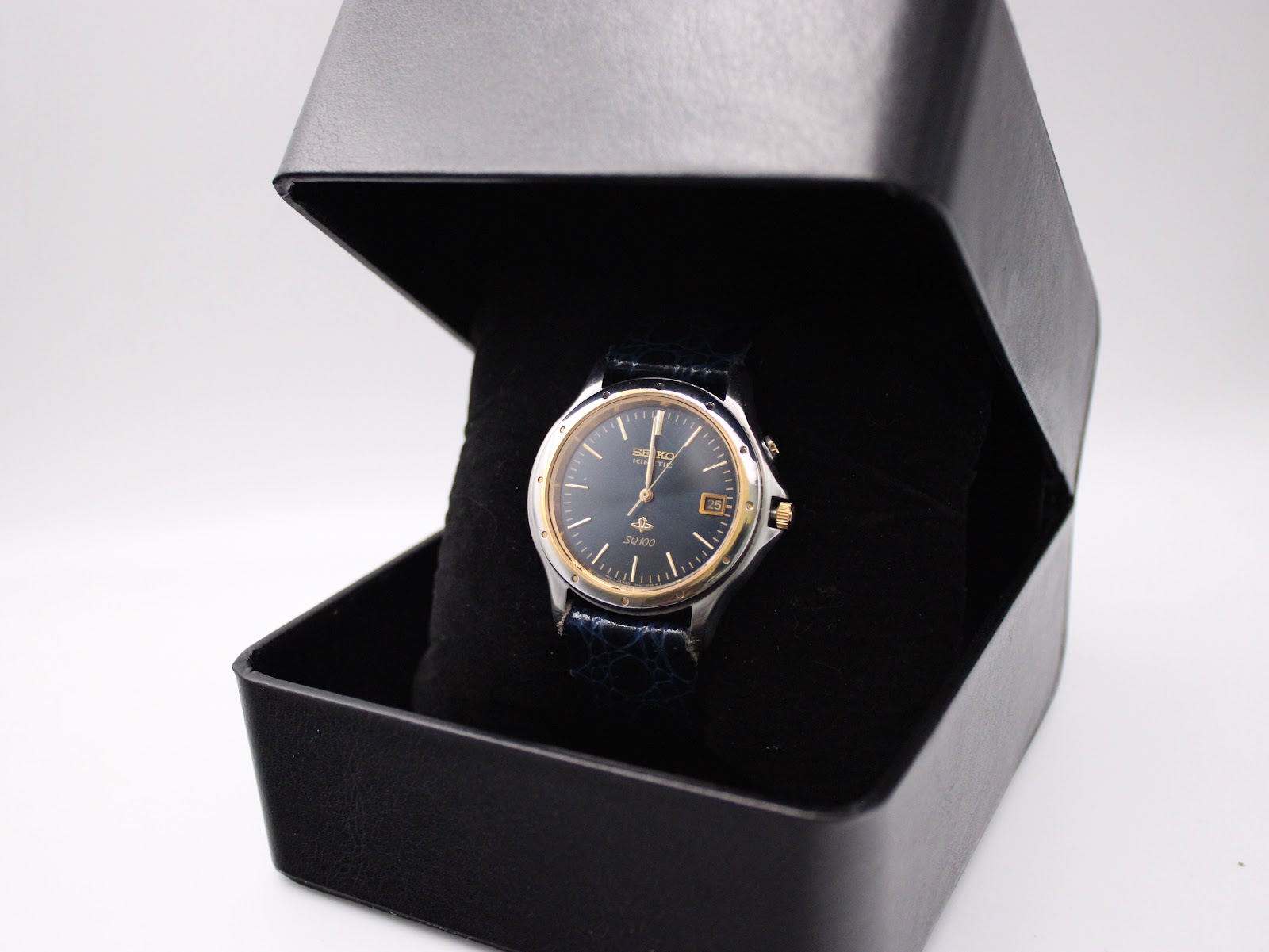 Seiko Kinetic watch with navy dial and leather strap displayed in a plain black presentation box.