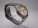Side profile view of the Seiko Kinetic watch on a stand, showcasing the ergonomic curve of the case and gold accents on the bezel.