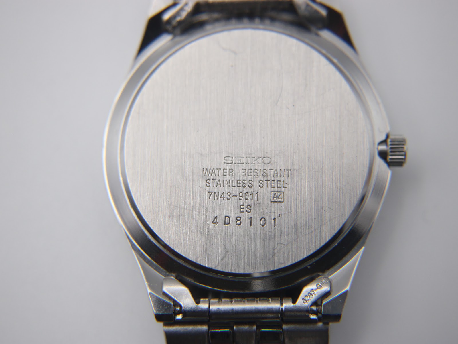 Close-up of the brushed stainless steel case back with Seiko model and serial number engravings.