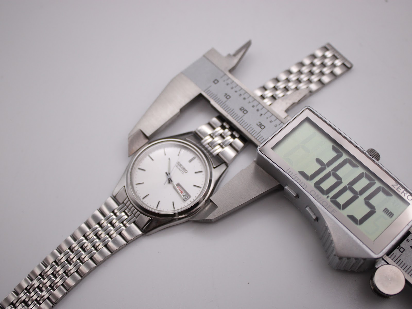Seiko watch dial being measured by a digital caliper, displaying 36.85 mm case diameter.