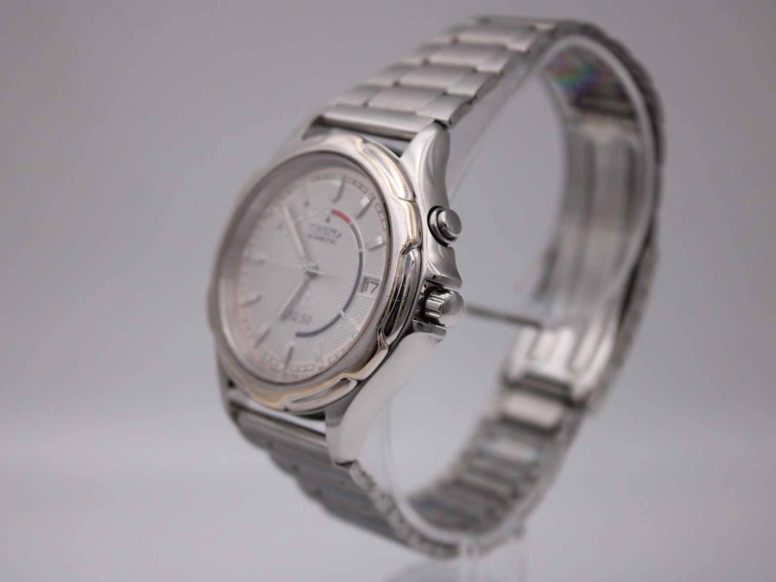 Angled side view of the Seiko Kinetic watch showing the polished and brushed case, gold-tone bezel ring, and crown.