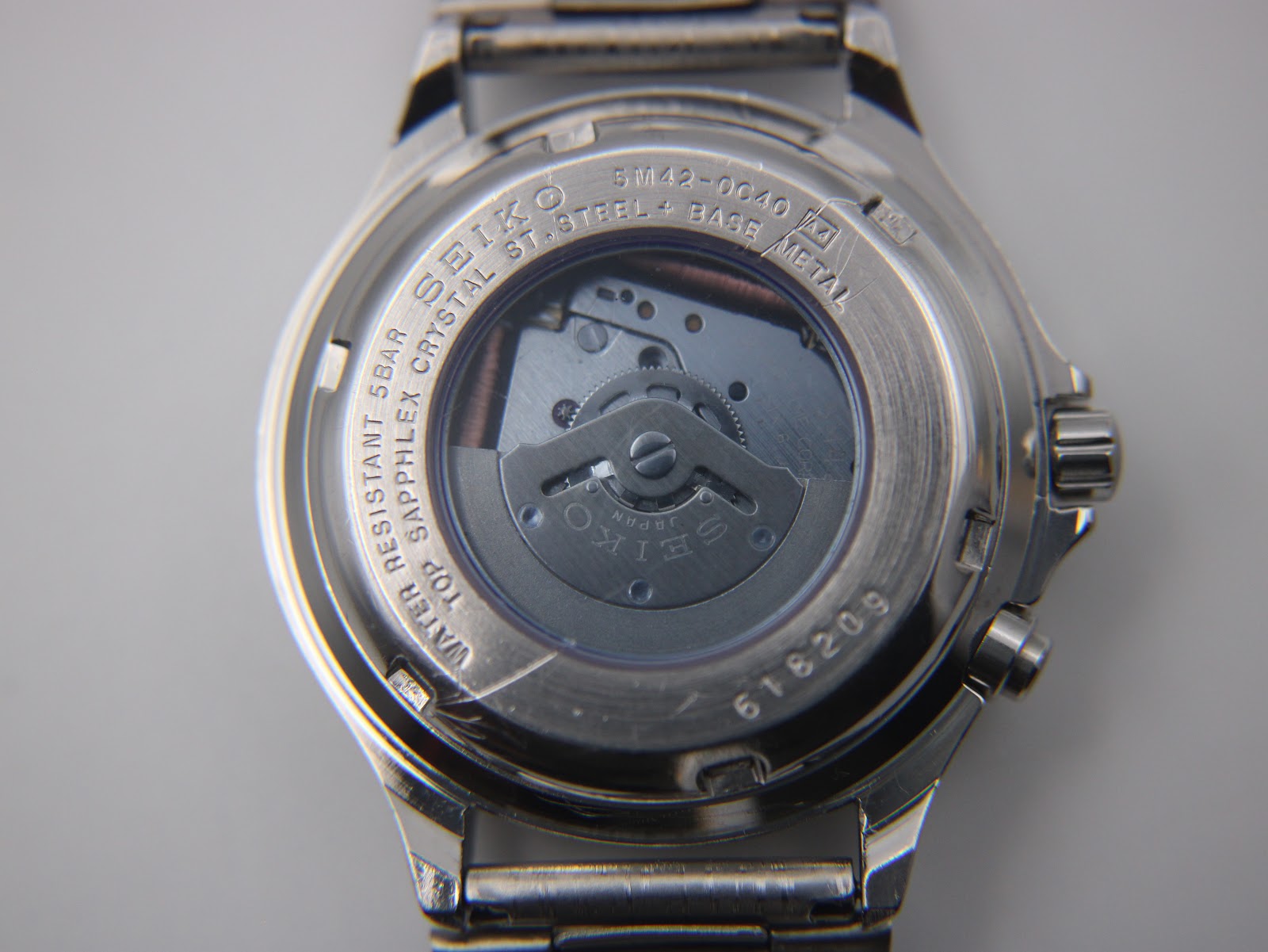 Close-up of the exhibition case back revealing the kinetic movement rotor, model number 5M42-0C40, serial number 618209, and water resistance.