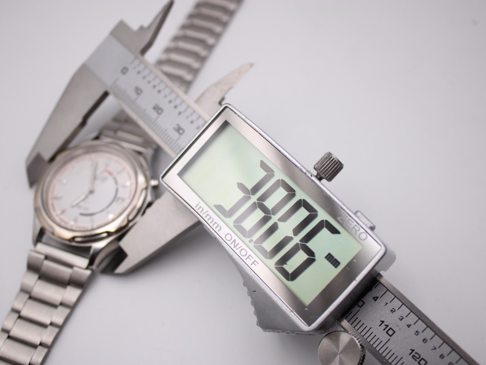 Digital caliper measuring the case diameter of the Seiko watch, showing a precise reading of 38.6mm.