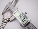 Digital caliper measuring the case diameter of the Seiko watch, showing a precise reading of 38.6mm.