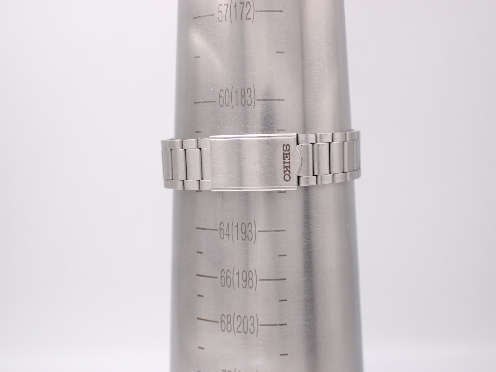 The integrated stainless steel bracelet of the Seiko watch on a wrist sizing gauge, indicating a maximum wrist size of 19.3cm.