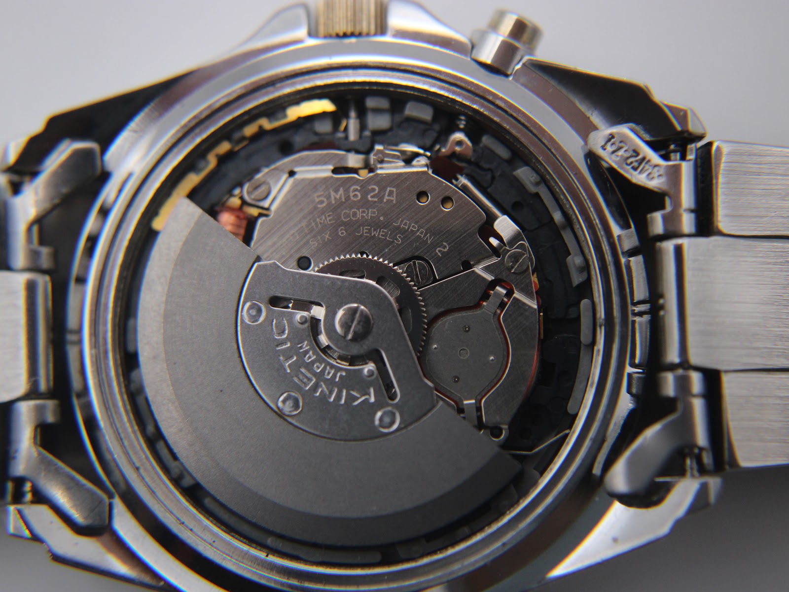 Macro shot revealing the Seiko 5M62A kinetic movement with its oscillating weight and jewels.