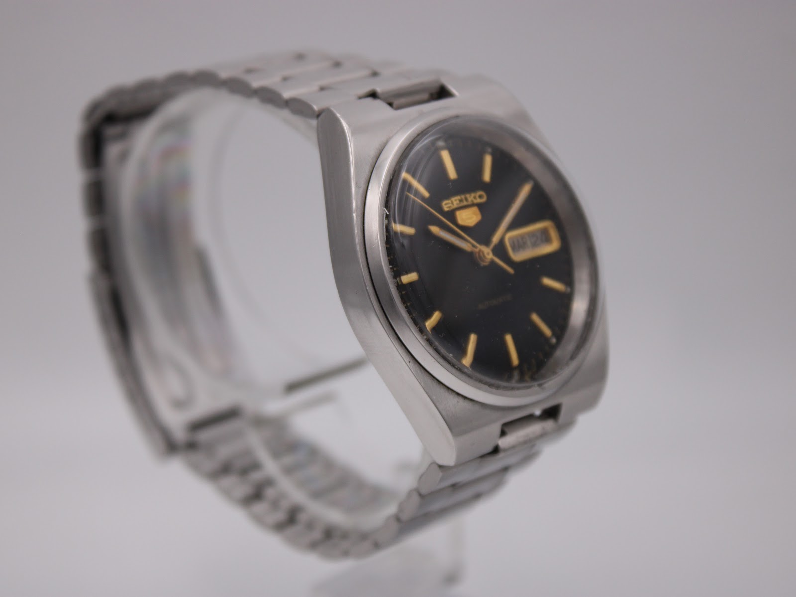 Another angled side view of the Seiko watch, highlighting the vintage case shape and acrylic crystal.