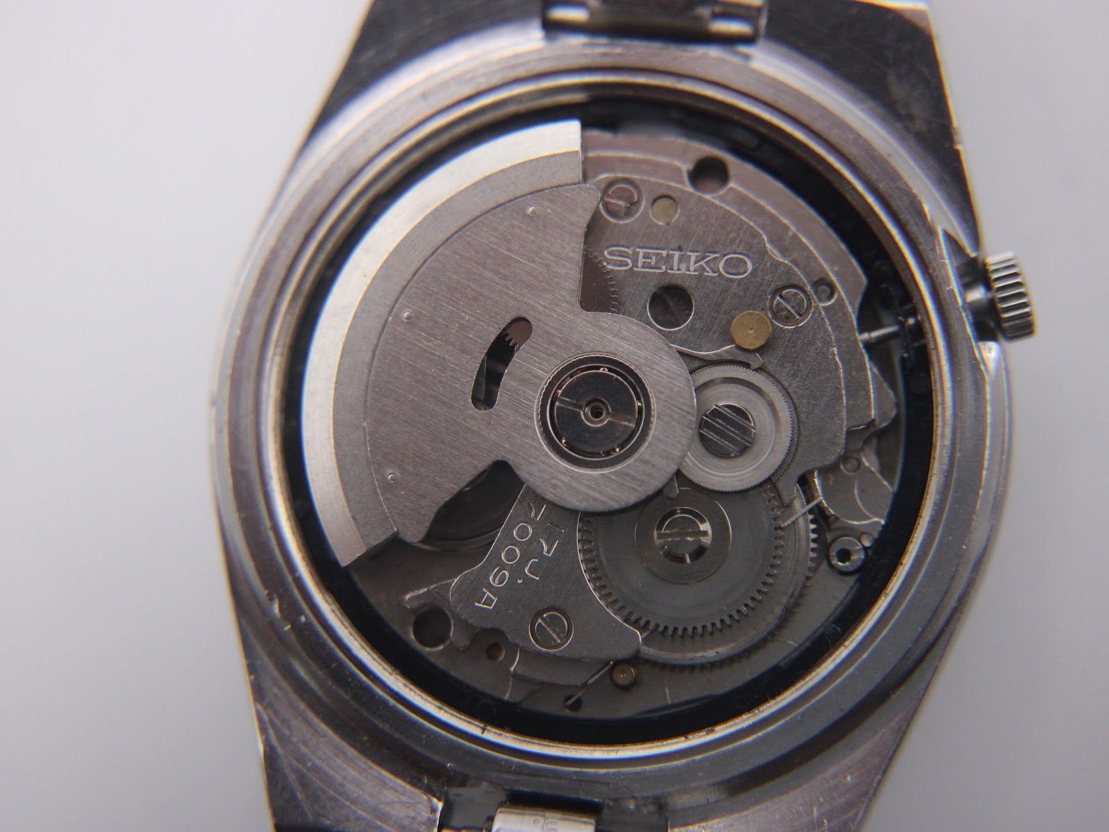 Close-up view of the Seiko 7009A automatic movement inside the watch, showing the rotor and gears.