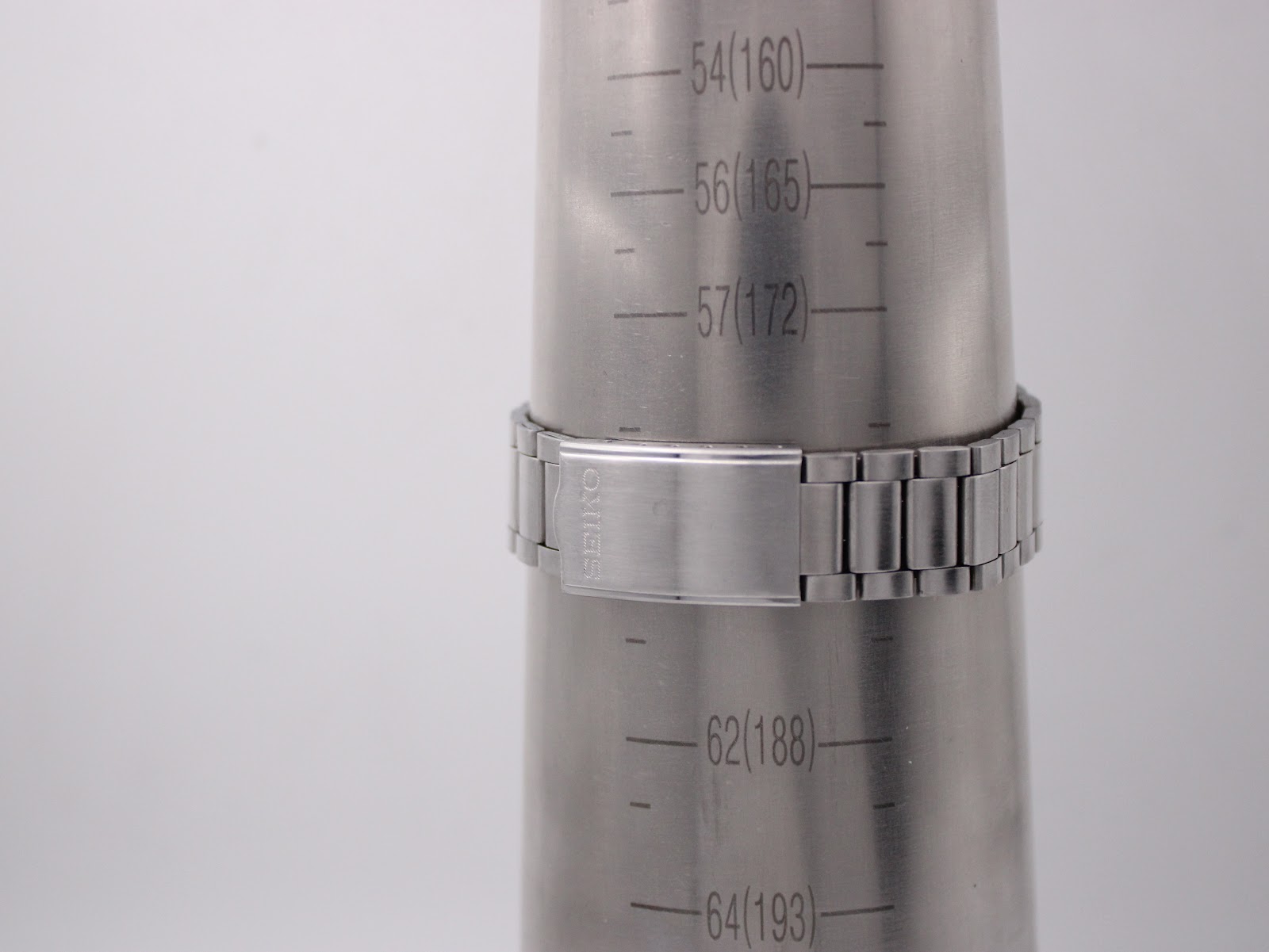 The stainless steel bracelet of the Seiko watch on a wrist sizing gauge, indicating a maximum wrist circumference of 185mm / 18.5cm, with the signed "SEIKO" clasp visible.