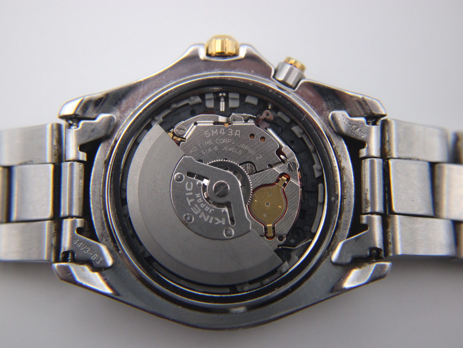 Close-up of the Seiko 5M43A kinetic movement visible through the display case back.