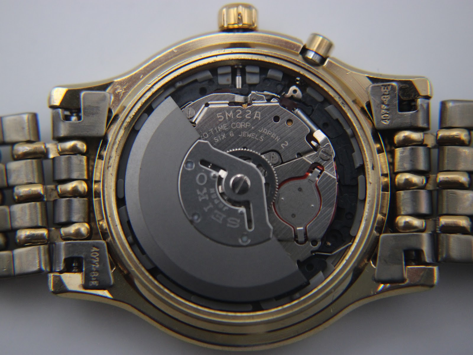 Close-up of the exposed Seiko 5M22A kinetic movement, showing the rotor and internal components.