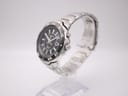 Angled view of the Seiko Kinetic watch showing the case side and integrated bracelet on a stand.
