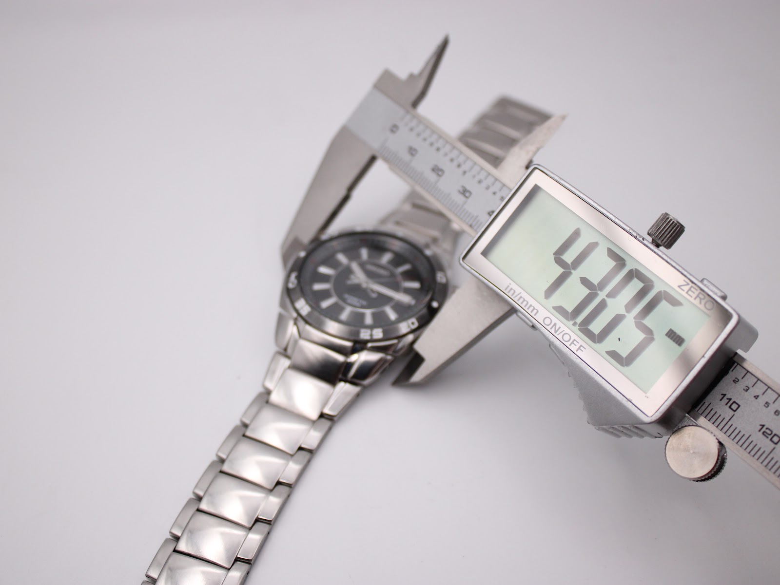 Digital caliper measuring the Seiko watch case diameter at 43.05mm, excluding the crown.