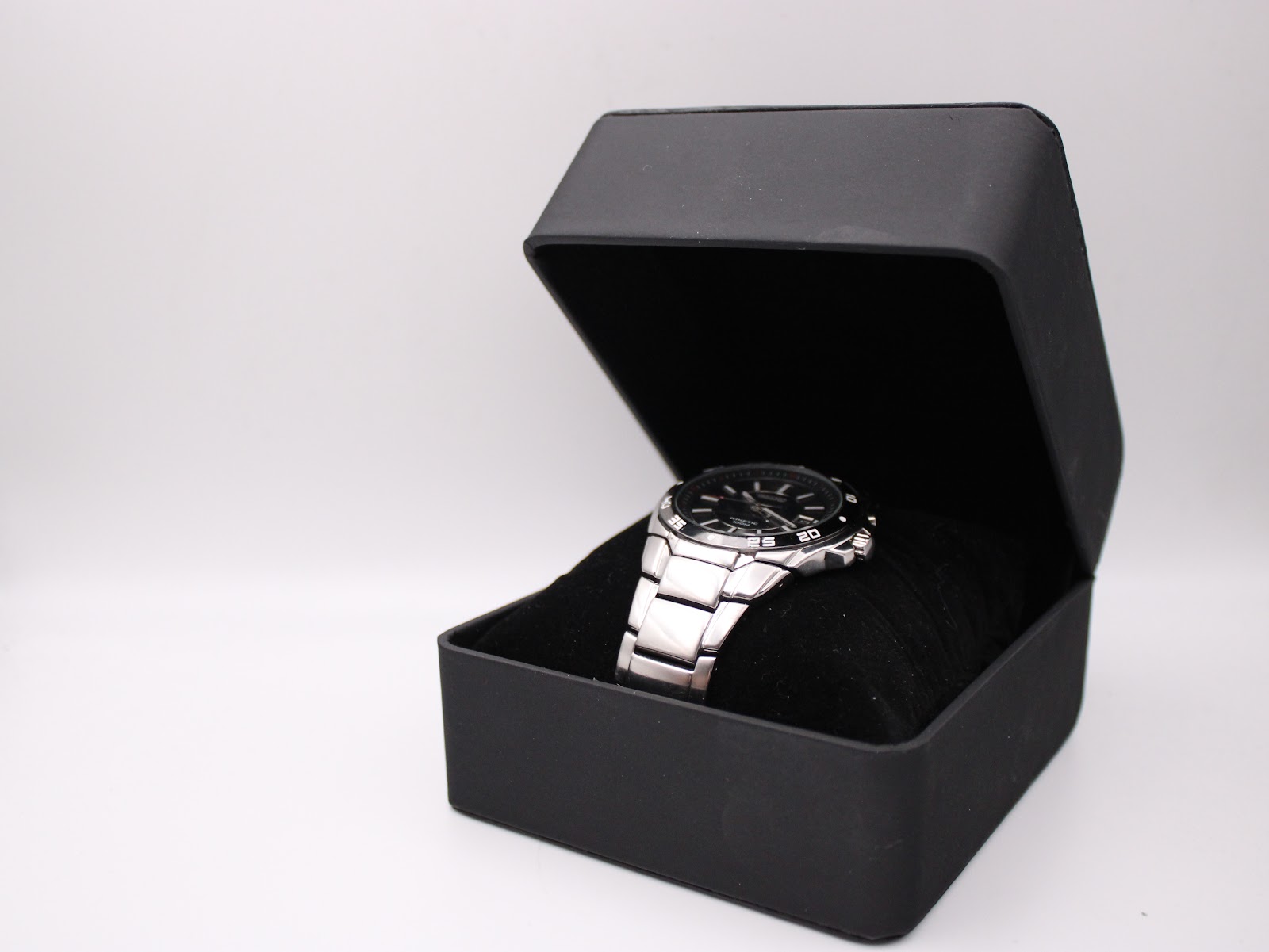 The Seiko Kinetic watch resting on a cushion inside a black presentation box, viewed from an angle.