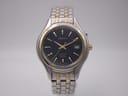 Front view of Seiko Kinetic two-tone watch with navy dial, gold-tone indices and hands, and date window.