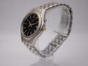 Angled side view of the Seiko Kinetic watch showing the two-tone case and bracelet on a clear display stand.