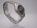 Angled side view from the other side of the Seiko Kinetic watch, highlighting the gold-tone crown and pusher.
