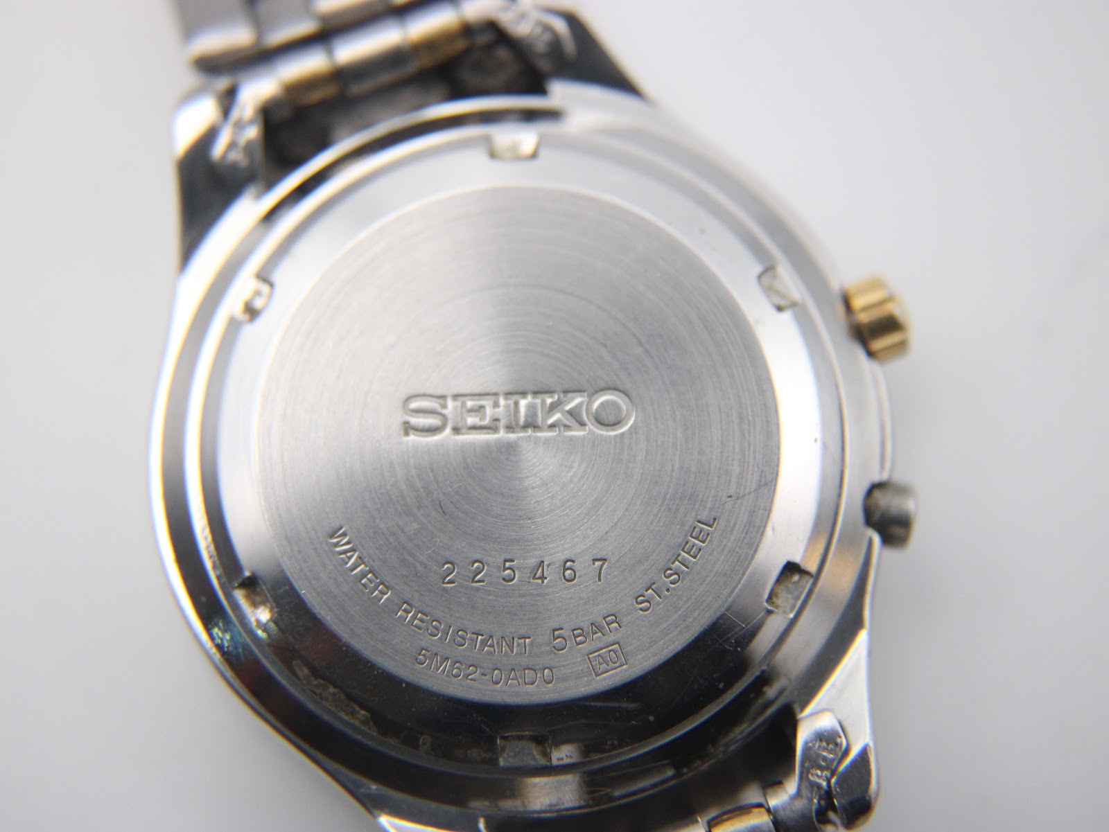 Close-up of the brushed stainless steel case back showing "SEIKO", "WATER RESISTANT 5BAR", "ST. STEEL", model 5M62-0AD0 and serial 225467.