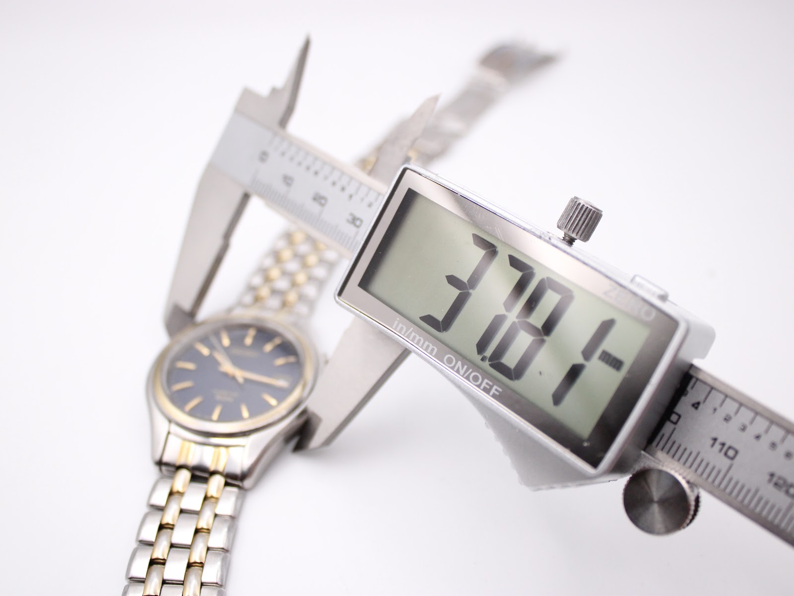 Digital caliper measuring the case diameter of the Seiko watch, showing a precise reading of 37.8mm.