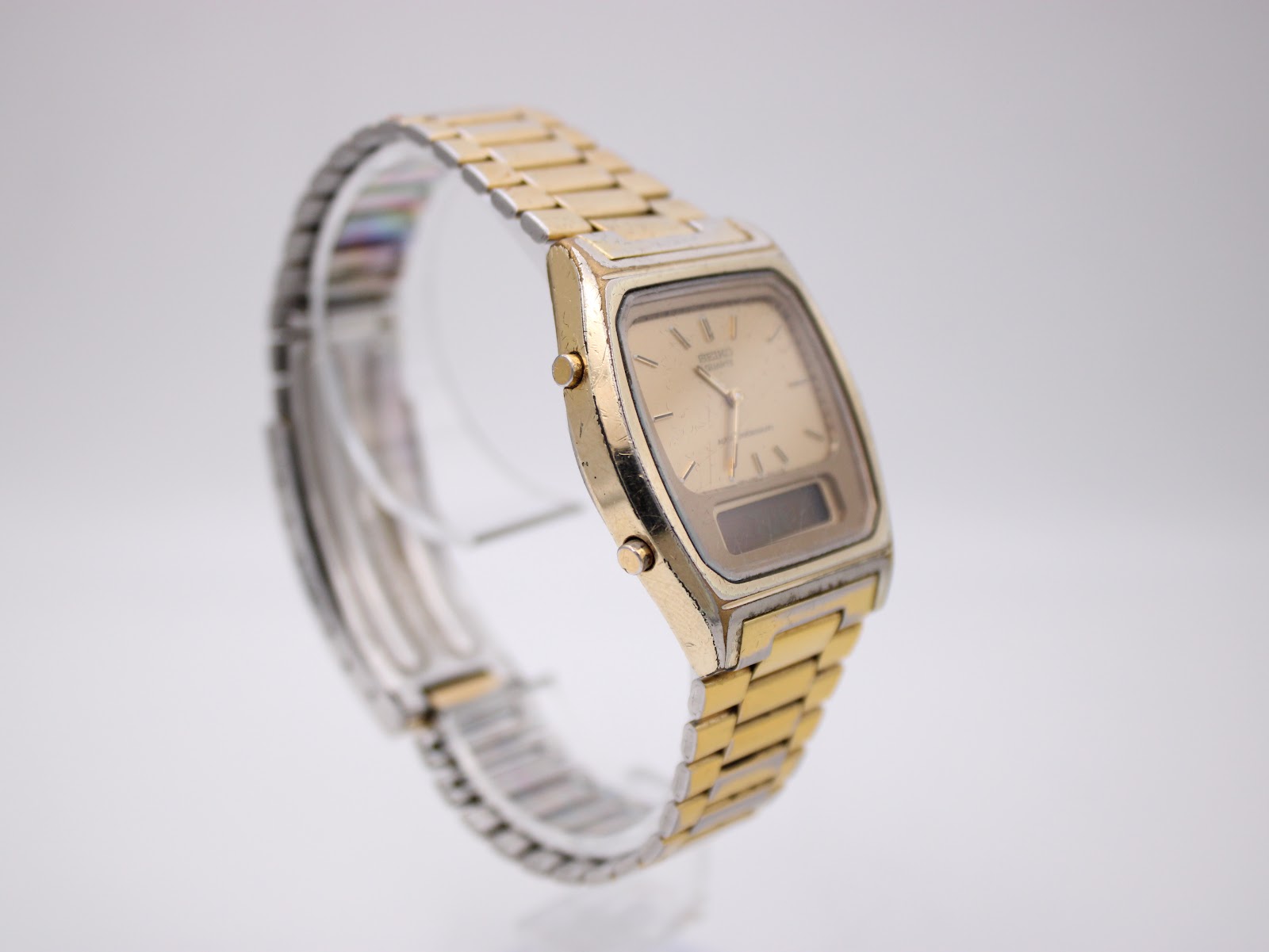 Another angled side view of the SEIKO ana-digi watch, highlighting the side pushers and integrated bracelet design.