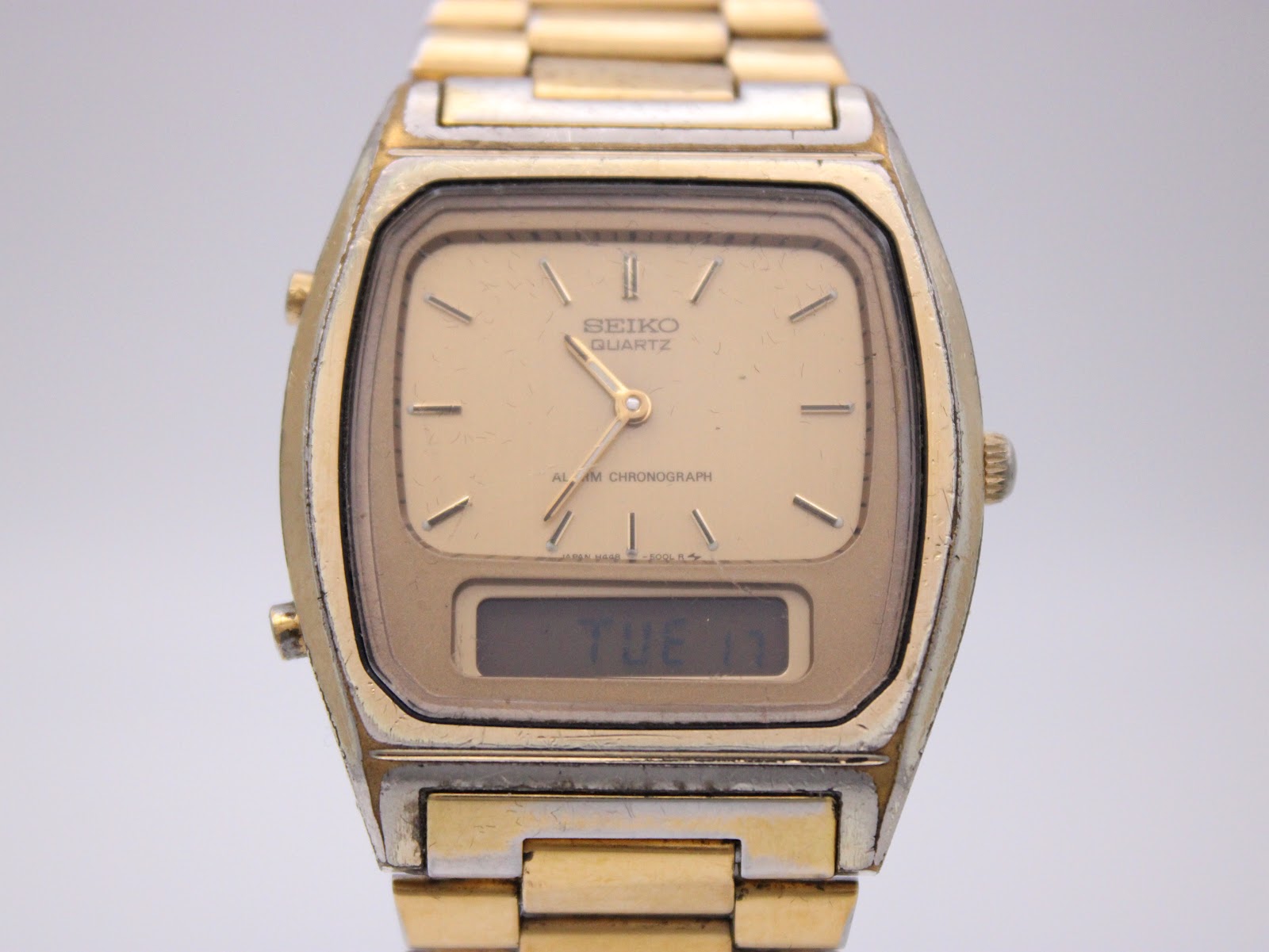 Close-up front view of the SEIKO H448-5000 dial, showing the analogue hands and the digital display reading "TUE 17".