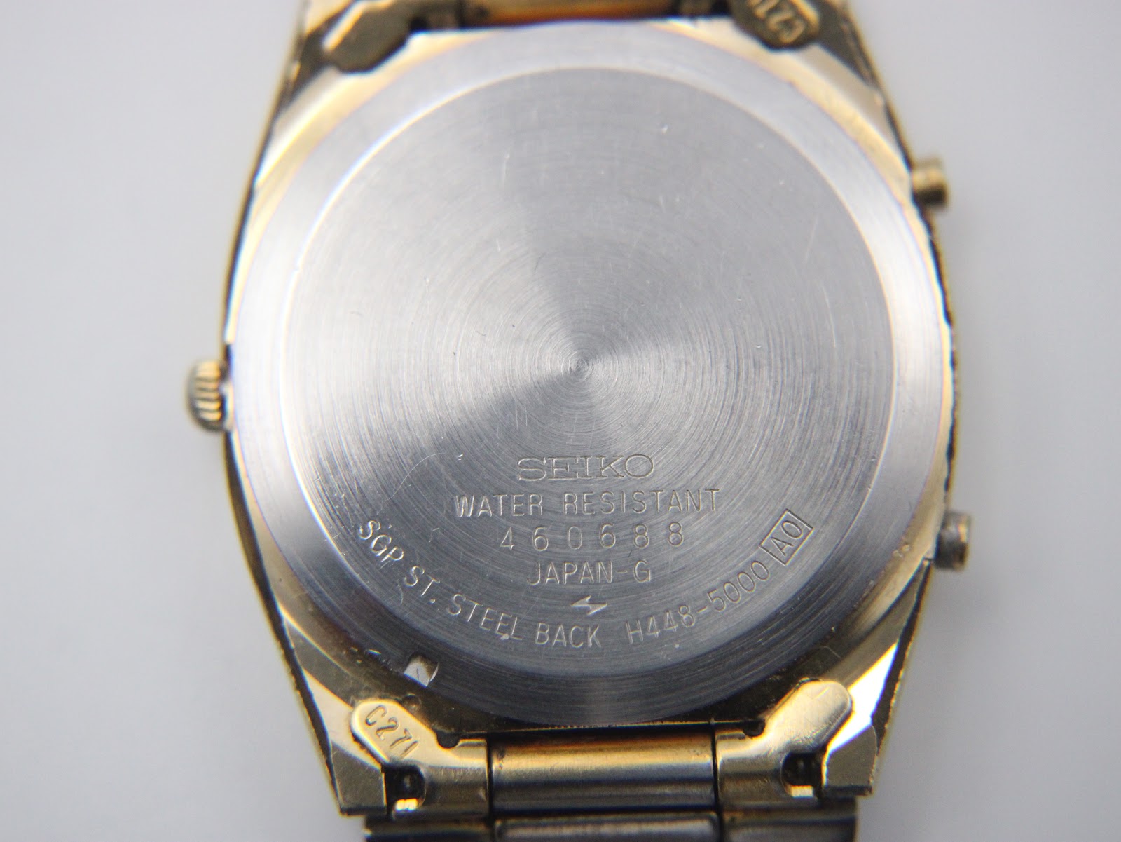 Close-up of the stainless steel case back, showing SEIKO branding, "WATER RESISTANT", serial number, and model reference.