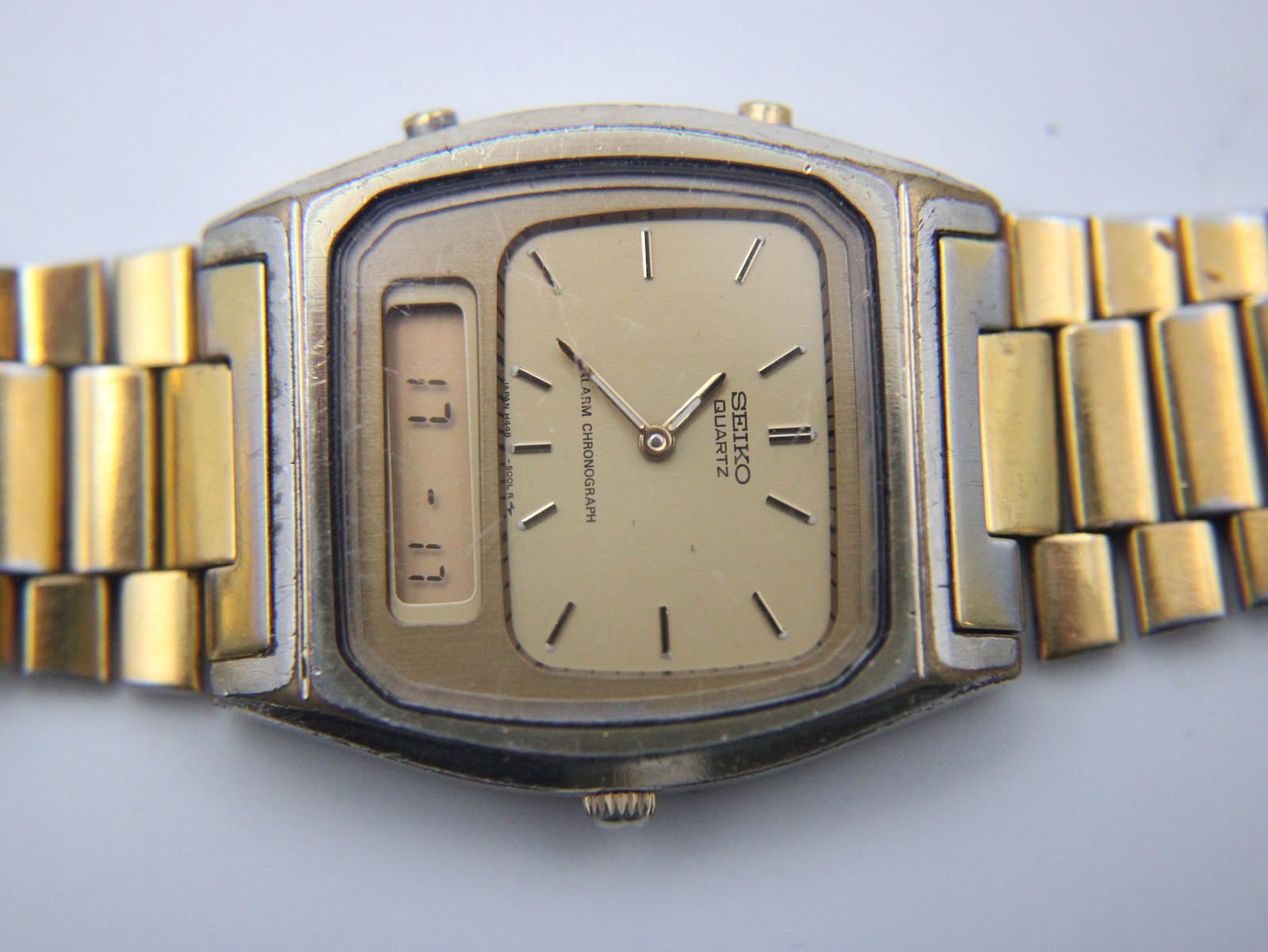 Overhead view of the watch, showcasing the square case shape and the gold-plated integrated steel bracelet.