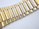 Close-up detail of the gold-plated steel bracelet links, showing wear and areas where the silver-tone base metal is visible.