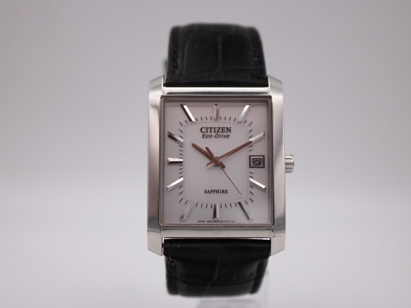 Straight front view of the Citizen Eco-Drive rectangular watch, showing its white dial, silver case, and black leather strap.