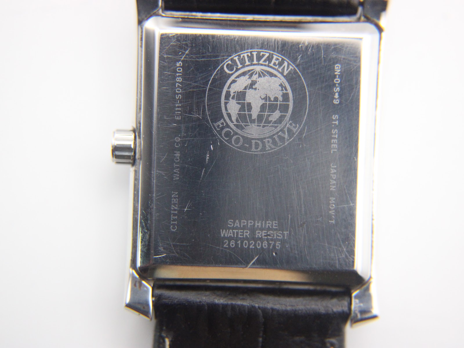 Close-up of the stainless steel case back of the Citizen watch, showing 'Citizen Eco-Drive' logo, 'Sapphire Water Resist', model E111-S078105, and serial number.