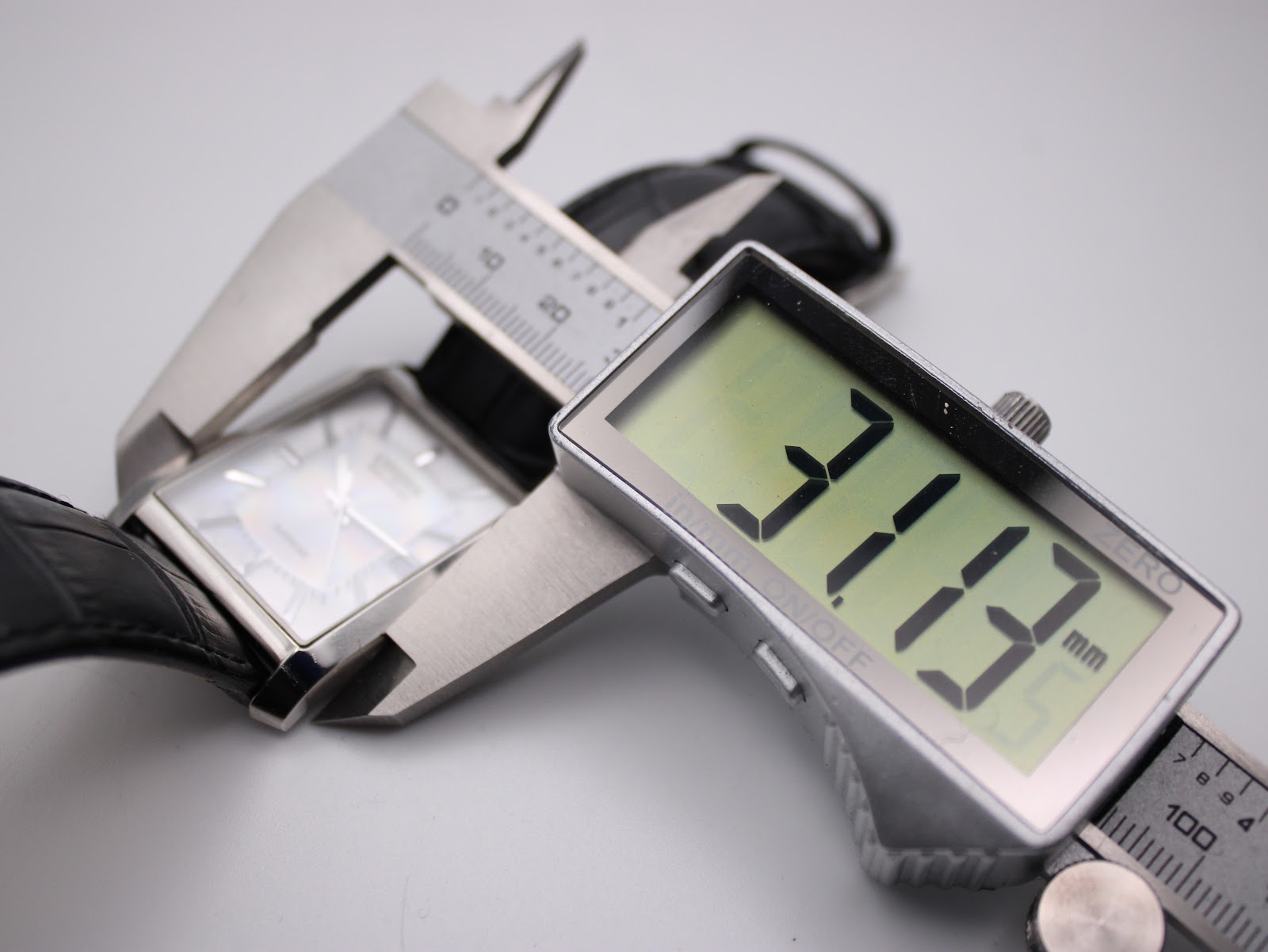 Close-up of a digital caliper measuring the width of the Citizen watch case, displaying 31.37 mm.