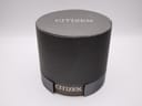 Top view of the closed dark grey circular Citizen original watch box with 'CITIZEN' logo on the side.