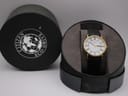 Front view of Citizen Eco-Drive watch in its open, dark grey cylindrical box.